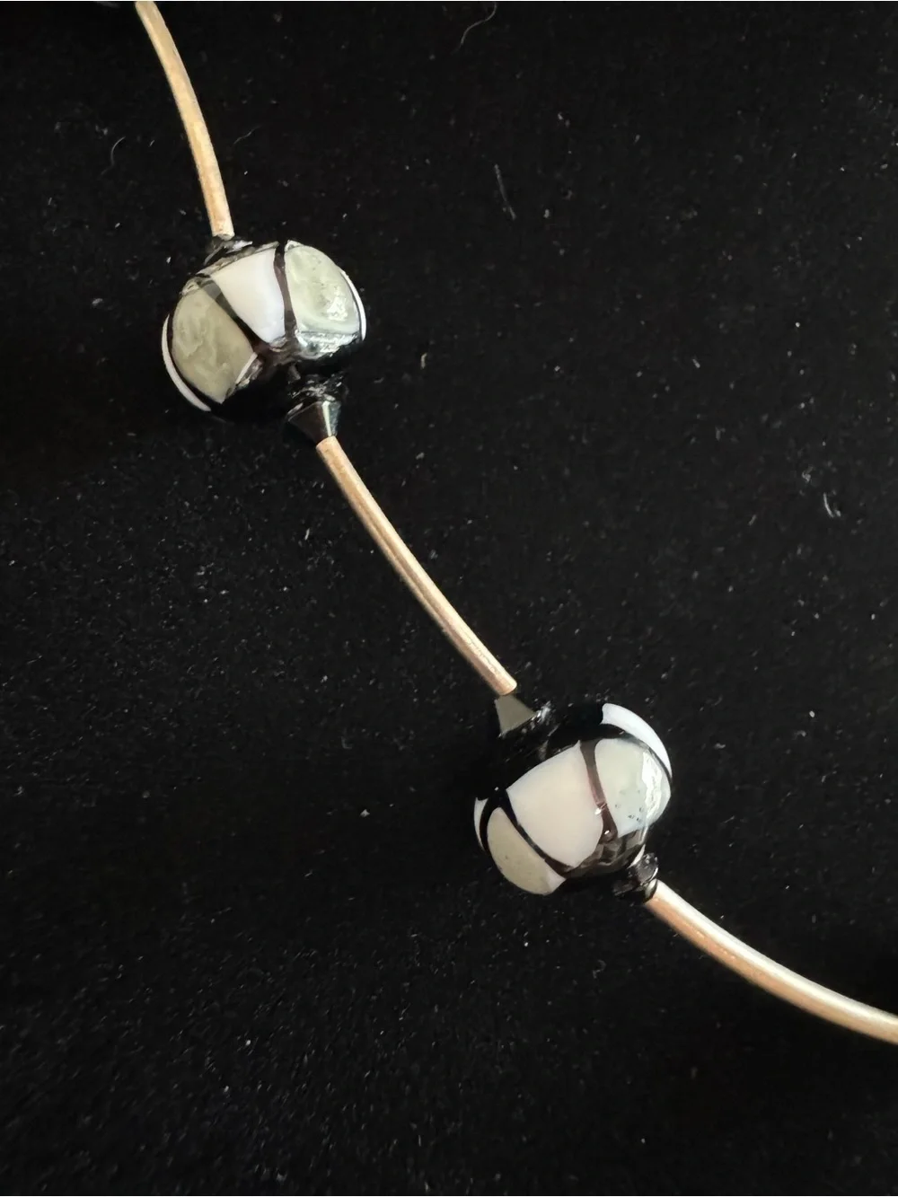 Black & silver geometric necklace featuring patterned spherical glass beads 22”